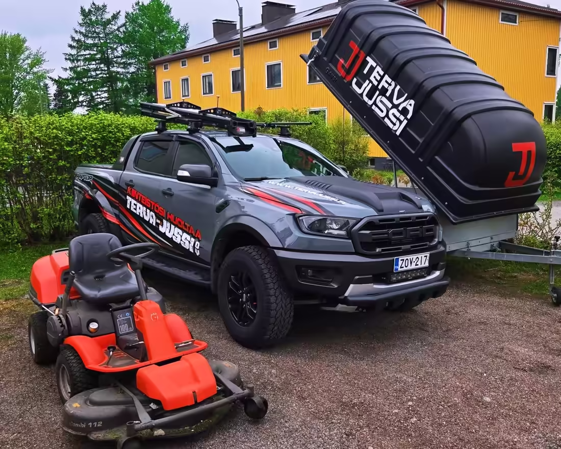 Terva-Jussin lava-auto, kippaava peräkärry ja ajoleikkuri taloyhtiön pihalla