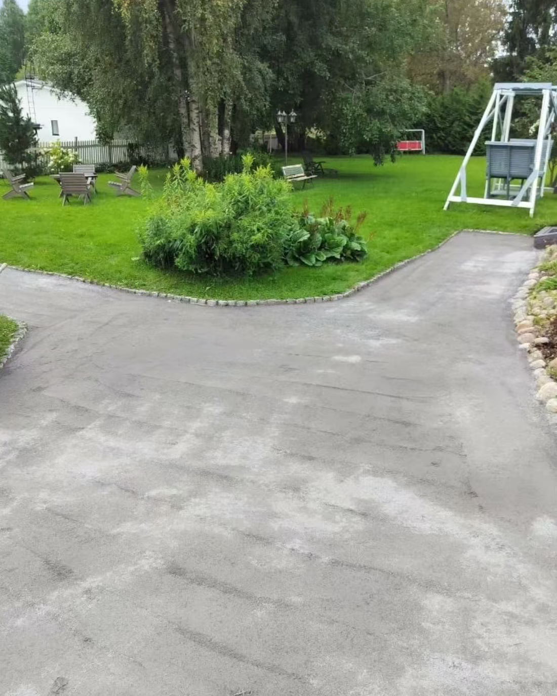 Leikattu nurmikko, istutusalue ja hoidettu pihatie omakotitalon pihalla